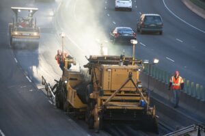 Road crews paving asphalt during a street resurfacing project