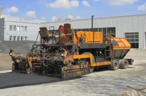 An asphalt paving machine at work on a roadway